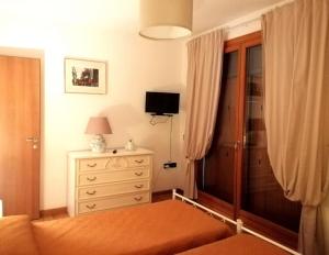 1 dormitorio con vestidor y ventana con TV en Bilocale NICOL 4 posti Padova ovest, en Padua