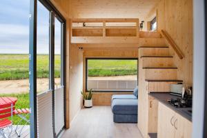 an interior view of a tiny house with a large window at Tiny House Nature 14 Zur Meerseite - Green Tiny Village Harlesiel in Carolinensiel