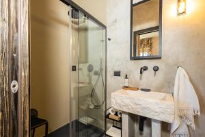 a bathroom with a sink and a shower at Via Roma Charming Rooms in Baunei