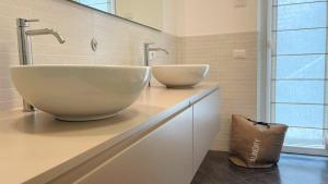 a bathroom with two sinks on a counter at LAKE VIEW APARTMENT in Argegno