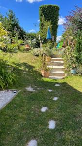 a garden with stepping stones in the grass at Gite Au Grenier Cosy in Lor