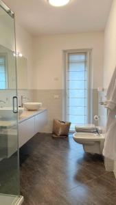 W łazience znajduje się umywalka, toaleta i lustro. w obiekcie LAKE VIEW APARTMENT w mieście Argegno
