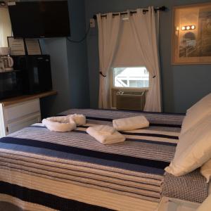 a bedroom with towels on a bed with a window at The New Oceanic Inn in Old Orchard Beach