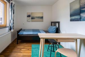 Cette chambre comprend un lit, une table et un bureau. dans l'établissement Ausblick Maisenbach, Talstraße, à Bad Liebenzell