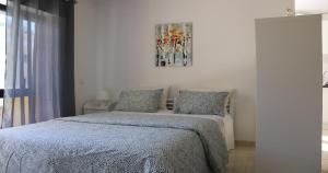 a bedroom with a bed and a painting on the wall at Casa Mirassol in Portimão