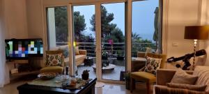 sala de estar con una gran puerta de cristal que da a un balcón en Saranda Center (above promenade), en Sarandë