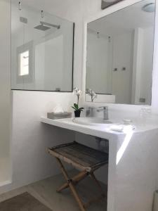 a white bathroom with a sink and a mirror at Loft via della Marina, Porto Rotondo in Porto Rotondo +6 photos