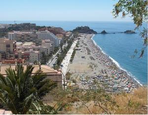 a view of a beach with buildings and the ocean at Paseo San Cristóbal in Almuñécar