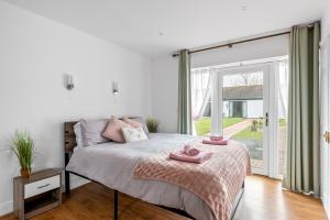 um quarto com uma cama com toalhas cor-de-rosa em Number 1 Lytton Tree Lodge em Reydon