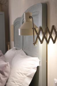 a lamp next to a bed with white sheets at B&B La Casa Pugliese in Foggia