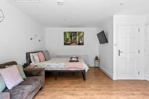 a living room with a couch and a bed at Number 2, Lytton Tree Lodge, Reydon, Southwold in Reydon