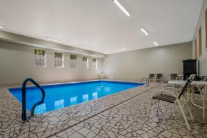 a pool in a room with a table and chairs at SureStay Plus Hotel by Best Western Topeka in Topeka