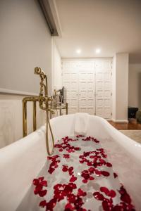 a bath tub filled with red roses in a bathroom at Casa de Âncora in Vila Praia de Âncora