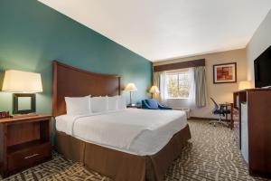 a hotel room with a bed and a television at SureStay Plus Hotel by Best Western Topeka in Topeka