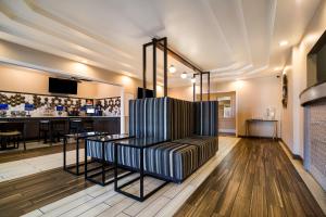 eine Bar mit gestreiftem Stuhl in der Mitte eines Zimmers in der Unterkunft SureStay Plus Hotel by Best Western Topeka in Topeka