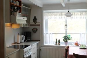 a kitchen with a stove and a window and a table at Cottage in Saksun in Saksun