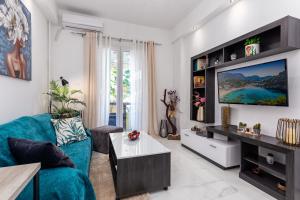 un soggiorno con un divano blu e una TV di Casa di Rosi, Seaview studio in corfu town a Città di Corfù