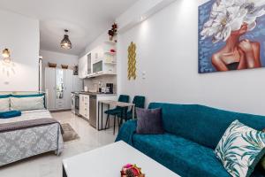 un soggiorno con un divano blu e una cucina di Casa di Rosi, Seaview studio in corfu town a Città di Corfù