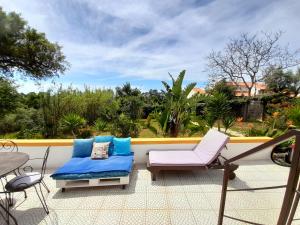 a patio with a couch and chairs on a balcony at Casa Lantana in Figueira da Foz