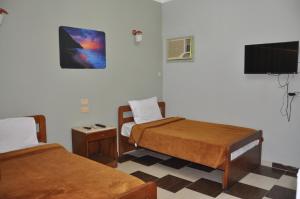 a room with two beds and a flat screen tv at Dahab Plaza Hotel in Dahab