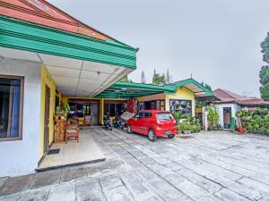 a red car parked in front of a building at OYO 92534 Fajar Indah Guest House in Karanganyar