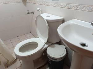 y baño con aseo blanco y lavamanos. en Isabelle Garden Villas 516, en Manila