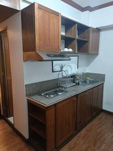 a kitchen with wooden cabinets and a counter top at Isabelle Garden Villas 516 in Manila