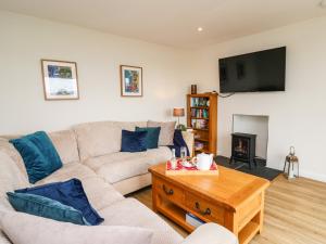 a living room with a couch and a coffee table at Gwynant in Ystrad Meurig