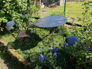 a picnic table in a garden with purple flowers at Au coeur des landes in Carneville