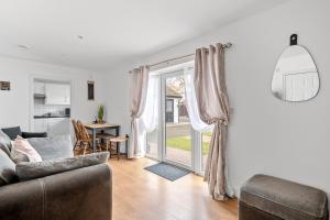 a living room with a couch and a table at Number 3, Lytton Tree Lodge, Reydon, Southwold in Reydon