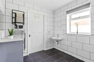 Baño blanco con lavabo y espejo en Number 3, Lytton Tree Lodge, Reydon, Southwold en Reydon