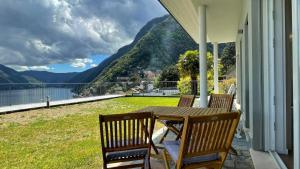 a porch with a table and chairs with a view of a mountain at LAKE VIEW APARTMENT in Argegno