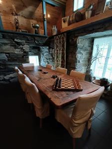 un tablero de ajedrez sobre una mesa de madera en una habitación en Orheimstunet - Gårdsferie for storfamilien der også hunden er velkommen, en Orhejm
