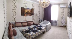 uma sala de estar com um sofá e uma mesa em Apartment near Tashkent metro station and convenient location em Tashkent