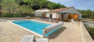 a swimming pool with a slide next to a house at Gîte myosotis Piscine Privée 4 Chambres in Lagorce