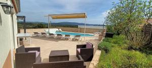 a patio with chairs and a pool with a umbrella at Gîte myosotis Piscine Privée 4 Chambres in Lagorce +21 photos