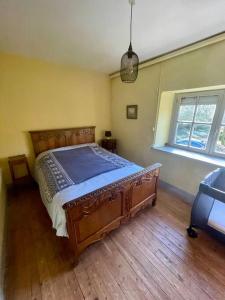 a bedroom with a large wooden bed in a room at Le Vaussourdet in Domfront