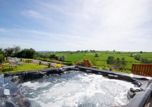 a hot tub in a backyard with a view at Trefnant Hall in Welshpool