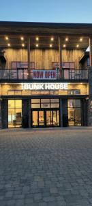 a building with a sign that reads now open at Bunk House in Madras