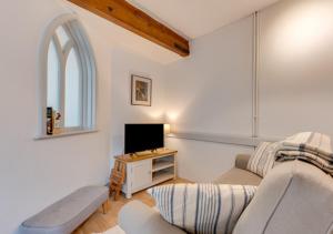 a living room with a couch and a tv at The Old Chapel Annexe in Nayland