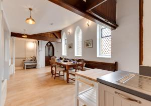 cocina y comedor con mesa y sillas en The Old Chapel Annexe, en Nayland