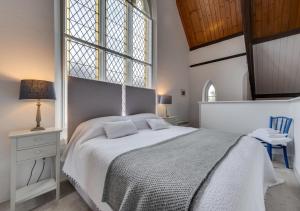 um quarto com uma cama grande e uma janela em The Old Chapel Annexe em Nayland