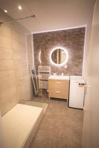 ein Bad mit einem Waschbecken und einem Kühlschrank in der Unterkunft LE MONDRIAN - Hôtel de ville - Confort - Paisible - Wi-Fi in Saint-Étienne