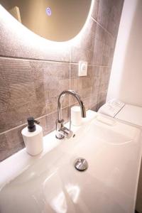ein Bad mit einem Waschbecken und einem Spiegel in der Unterkunft LE MONDRIAN - Hôtel de ville - Confort - Paisible - Wi-Fi in Saint-Étienne