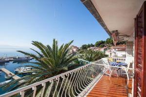 balcone con vista sull'acqua e su una palma di Apartments Teo a Podgora