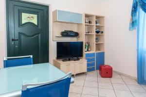 um quarto com uma mesa, uma porta e uma televisão em A27 - Poggio, quadrilocale con vista sul mare di Portonovo em Ancona
