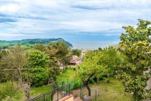 uma vista para um quintal com árvores e uma casa em A27 - Poggio, quadrilocale con vista sul mare di Portonovo em Ancona
