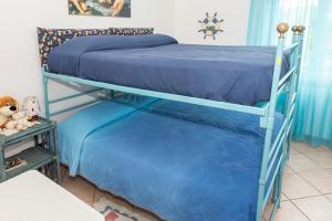 2 beliches com lençóis azuis num quarto em A27 - Poggio, quadrilocale con vista sul mare di Portonovo em Ancona