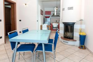 uma mesa azul e cadeiras numa cozinha com lareira em A27 - Poggio, quadrilocale con vista sul mare di Portonovo em Ancona