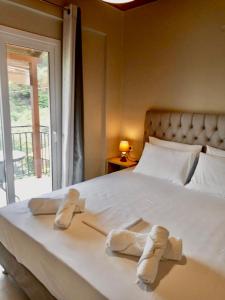 ein Bett mit zwei Paar Hausschuhen darauf in der Unterkunft Oliveto e mare in Syvota